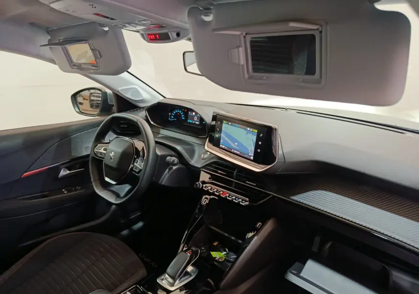 Intérieur de la Peugeot 208 électrique gris clair, vue côté conducteur sur tableau de bord et écran tactile central.