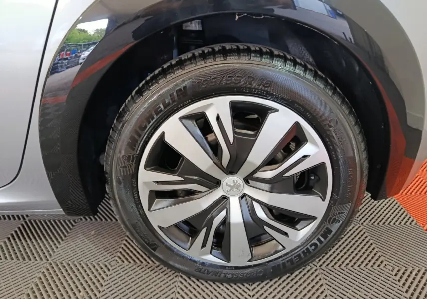 Gros plan sur la roue avant gauche gris clair de la Peugeot 208 Electrique Active Business avec jante stylisée.