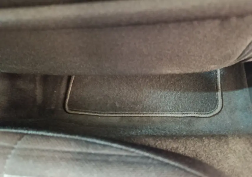 Gros plan sur le tapis de sol gris foncé sous le siège avant d'une Peugeot 208 électrique Active Business 2020.