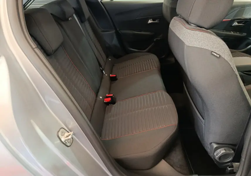 Vue intérieure côté droit sur la banquette arrière noire avec surpiqûres rouges d'une Peugeot 208 Electrique Active Business gris clair 2020.