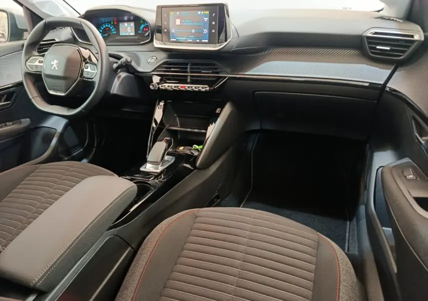 Intérieur de la Peugeot 208 Electrique Active Business 2020 vu côté passager, tableau de bord noir avec écran tactile central.