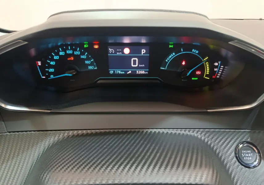 Tableau de bord numérique de Peugeot 208 électrique, affichage multi-fonctions avec compteur et bouton démarrage visible