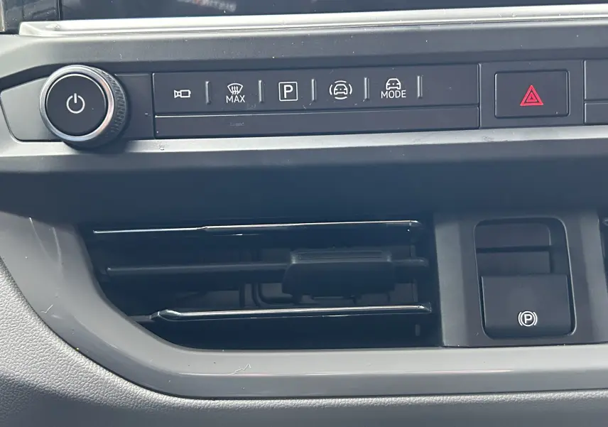 Vue rapprochée du tableau de bord du Volkswagen Transporter T7, montrant les commandes de climatisation et d'assistance au stationnement.