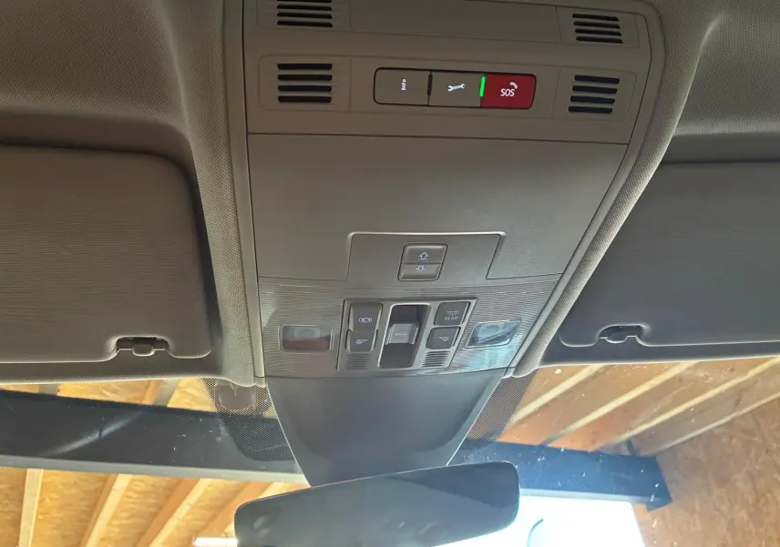 Vue intérieure du plafond avant du Volkswagen Tiguan 2023 gris, montrant les commandes du toit ouvrant et l'éclairage d'ambiance.