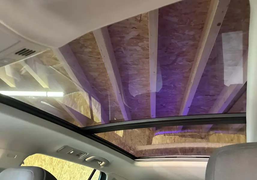 Vue intérieure du toit ouvrant panoramique du Volkswagen Tiguan 2023, avec ciel visible à travers le verre teinté.