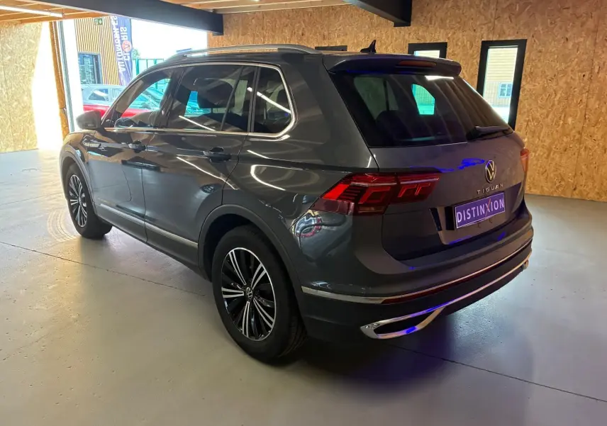 Vue 3/4 arrière droit d'un Volkswagen Tiguan gris 2023 avec feux LED et jantes alliage noires.