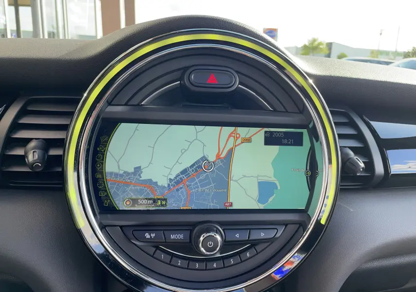 Vue rapprochée de la console centrale MINI F56 Cooper S 2015 avec écran GPS circulaire et éclairage LED ambiant.