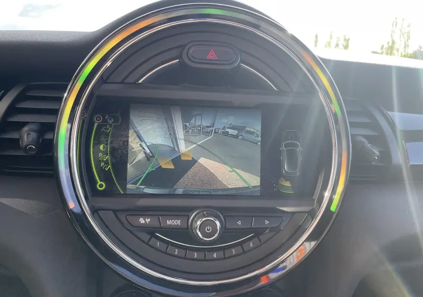 Écran central rond de la MINI F56 Cooper S 2015 montrant la caméra de recul avec guidage et alertes de proximité.