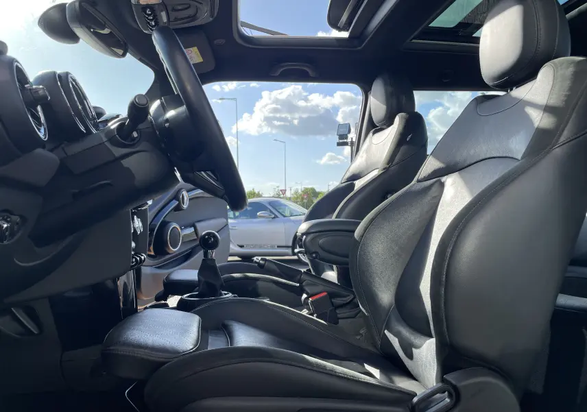 Intérieur de la MINI F56 Cooper S 2015 vu côté conducteur, sièges en cuir noir et toit ouvrant panoramique.