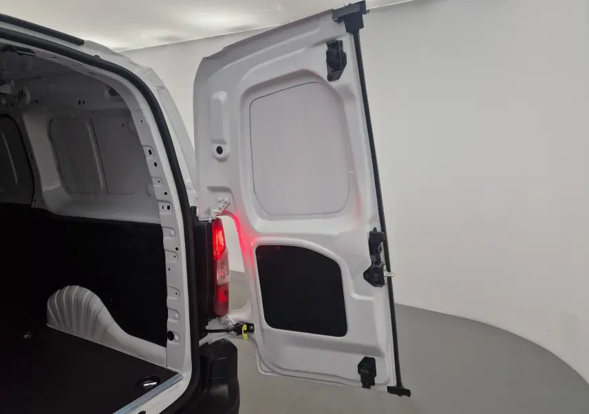 Vue intérieure du coffre arrière droit ouvert du Peugeot Partner blanc, mettant en valeur l'espace de chargement vide.