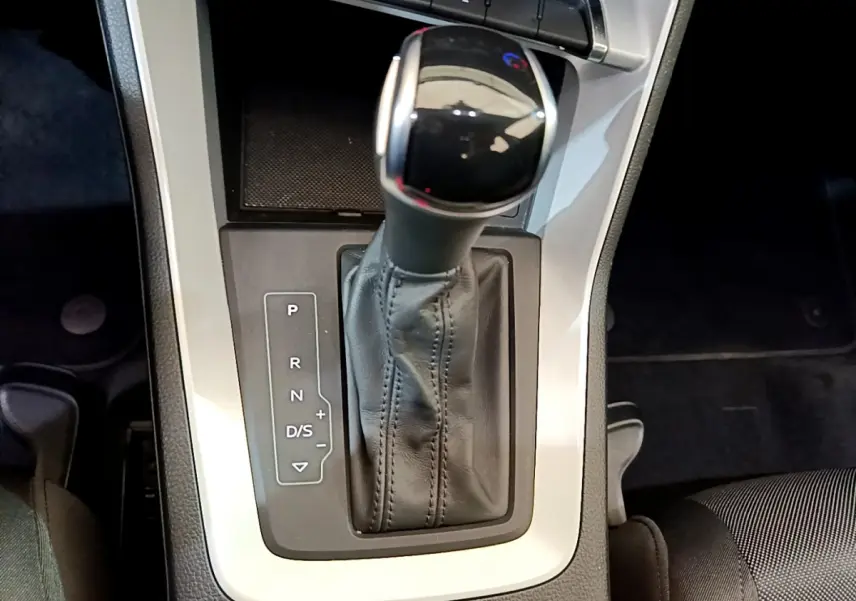 Vue rapprochée de la commande de boîte automatique noire et argentée dans l’Audi Q3 35 TDI 2021, intérieur sombre.