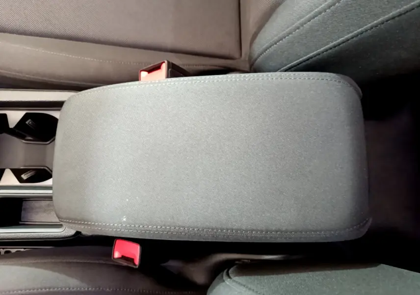 Vue rapprochée de l'accoudoir central noir et des sièges avant en tissu dans l'Audi Q3 35 TDI 2021.