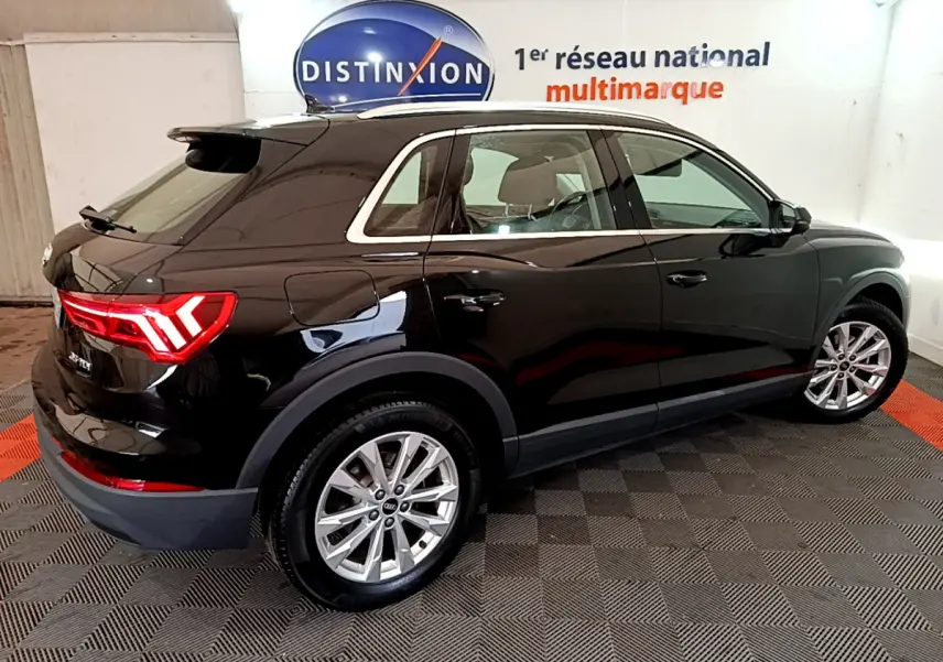 Audi Q3 35 TDI noir vue 3/4 arrière droit, feux LED allumés, jantes alliage et rétroviseurs électriques visibles.