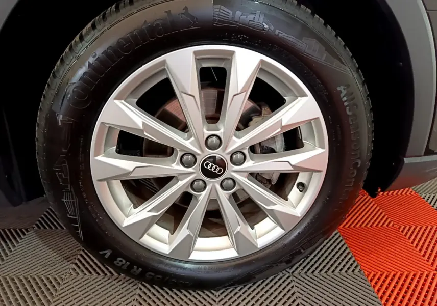 Gros plan sur la roue avant droite d’un Audi Q3 noir 35 TDI 150 S tronic avec jante argentée à plusieurs branches.