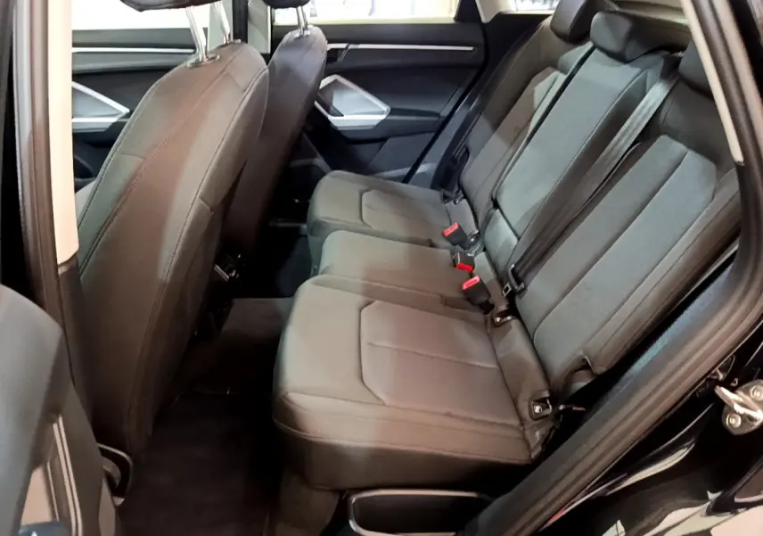 Vue intérieure côté droit sur la banquette arrière grise de l'Audi Q3 35 TDI Business Line noire de 2021.