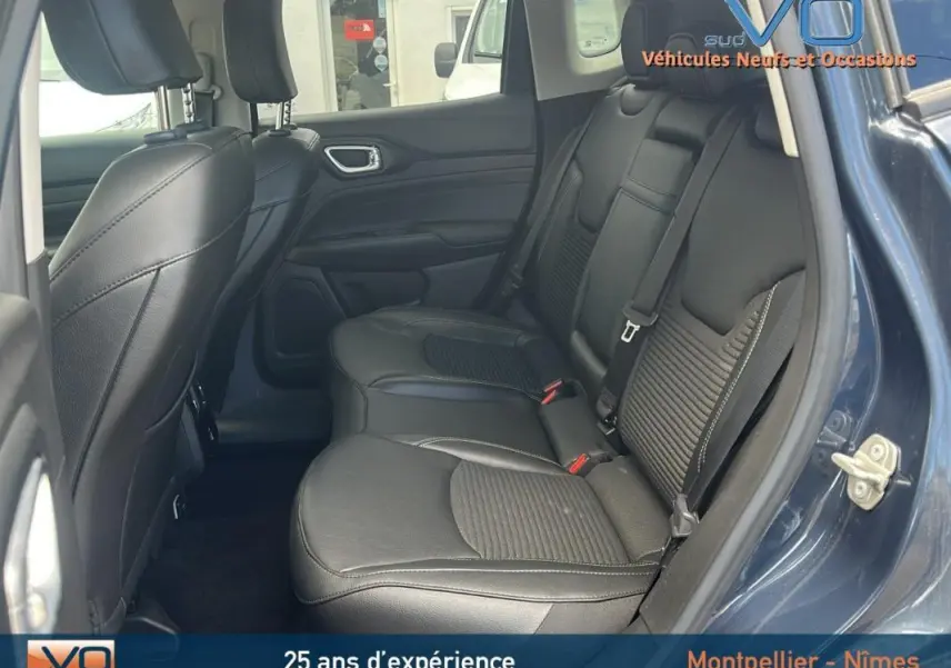 Vue intérieure côté droit des sièges arrière en cuir noir du Jeep Compass bleu 2023 avec porte ouverte.