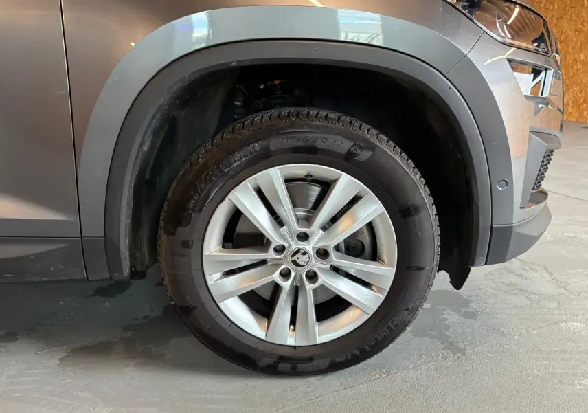 Gros plan sur la jante alu 17'' avant droite du Skoda Kodiaq gris avec protection noire des passages de roue.