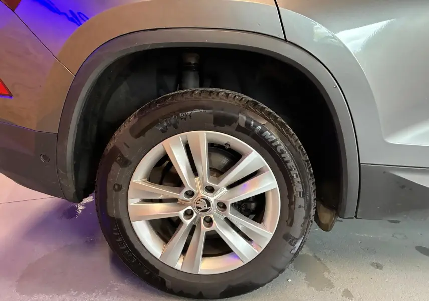 Gros plan sur la roue arrière droite en jante alu 17'' du Skoda Kodiaq gris avec passage de roue noir mat.