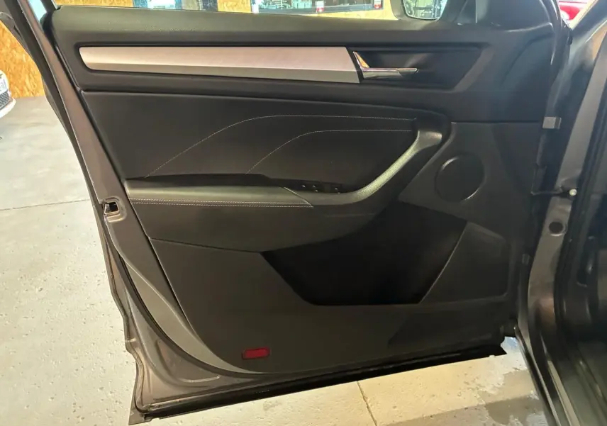 Vue intérieure de la porte avant gauche gris foncé du Skoda Kodiaq 2023 avec insert décoratif aluminium brossé.