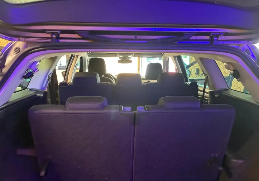 Vue arrière intérieure du Skoda Kodiaq gris 7 places, montrant la troisième rangée de sièges relevée.
