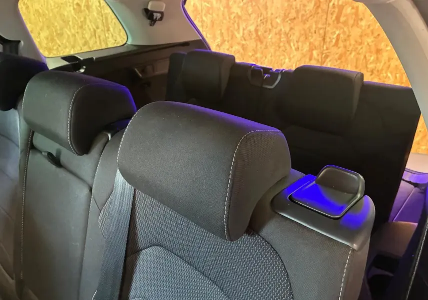 Vue rapprochée des sièges arrière noirs en tissu du Skoda Kodiaq 7 places, avec appuie-têtes et ceintures visibles.