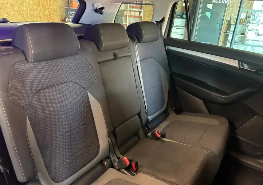Vue intérieure côté droit des sièges arrière en tissu noir du Skoda Kodiaq 7 places avec appuie-têtes et ceintures visibles.