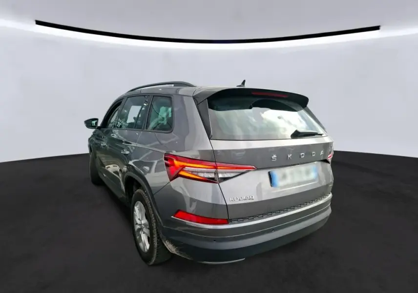 Vue de profil côté gauche d'un Skoda Kodiaq gris 2023 avec jantes alu 17 pouces dans un garage.