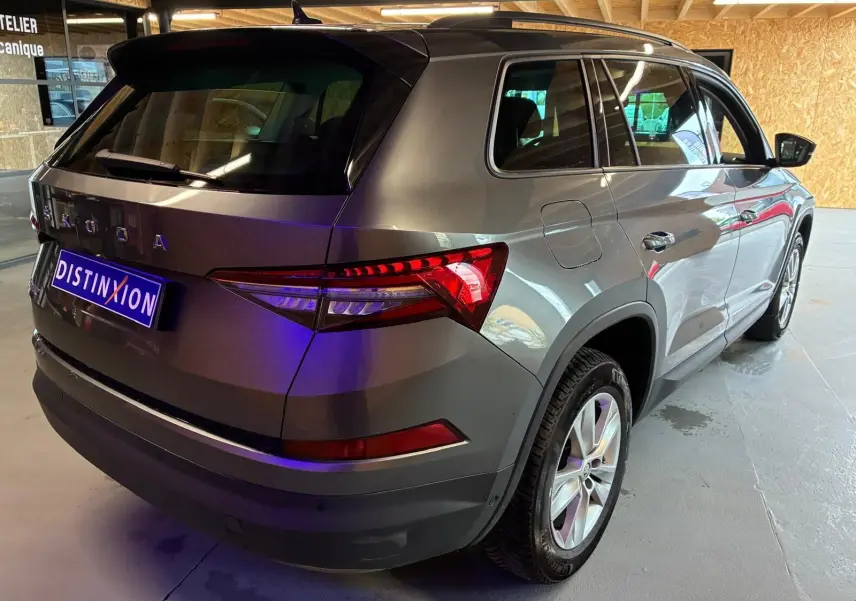 Vue 3/4 arrière droite d’un Skoda Kodiaq gris métallisé avec jantes alu 17 pouces dans un garage.