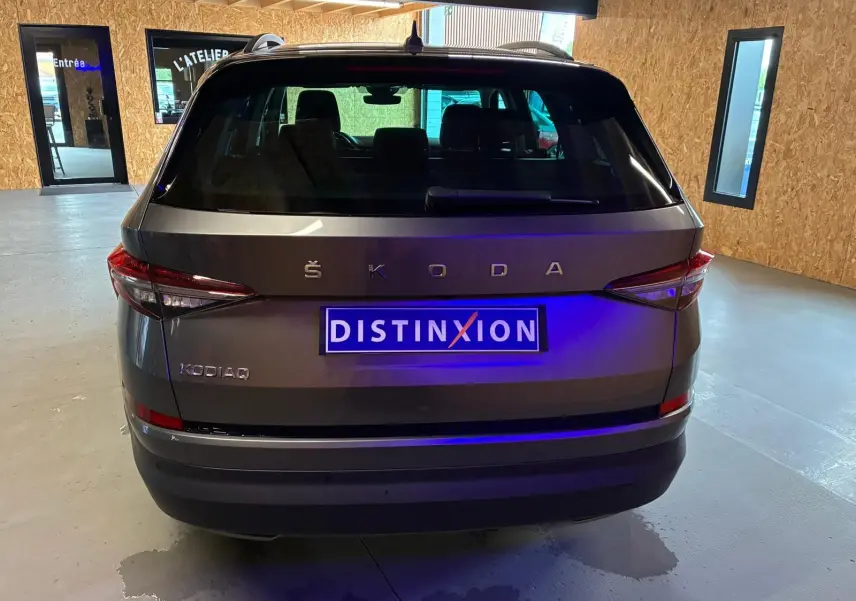 Vue arrière d'un Skoda Kodiaq gris 2023 avec feux LED et plaque d'immatriculation Distinxion visible en intérieur.