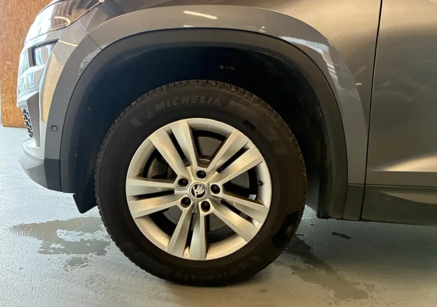 Gros plan sur la roue avant gauche du Skoda Kodiaq gris, avec jante alu 17 pouces et passage de roue noir mat.