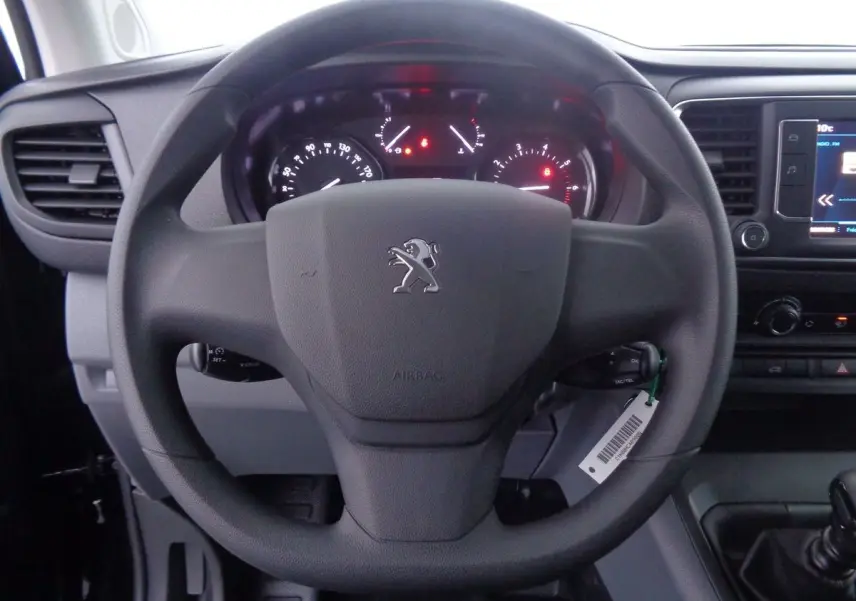 Vue rapprochée du volant noir du Peugeot Expert Fourgon 2022 avec tableau de bord et écran tactile visibles à droite.