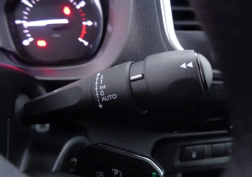 Gros plan sur la commande d’essuie-glace du Peugeot Expert Fourgon noir métal, tableau de bord en arrière-plan flou.