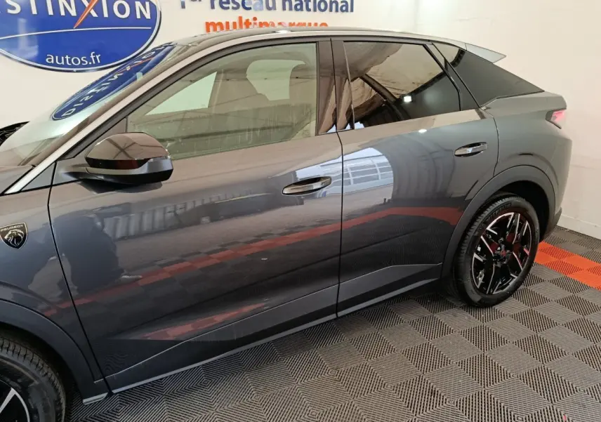 Profil côté gauche du Peugeot 3008 gris foncé 2025 avec jantes noires et logo lion visible sur l'aile avant.