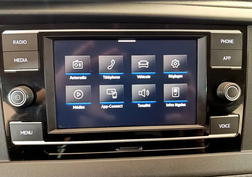 Écran tactile central du tableau de bord du Volkswagen Transporter 2.0 TDi blanc, affichant les options multimédias.