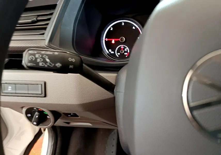 Vue intérieure du tableau de bord du Volkswagen Transporter blanc 2021, avec volant et compte-tours visibles.