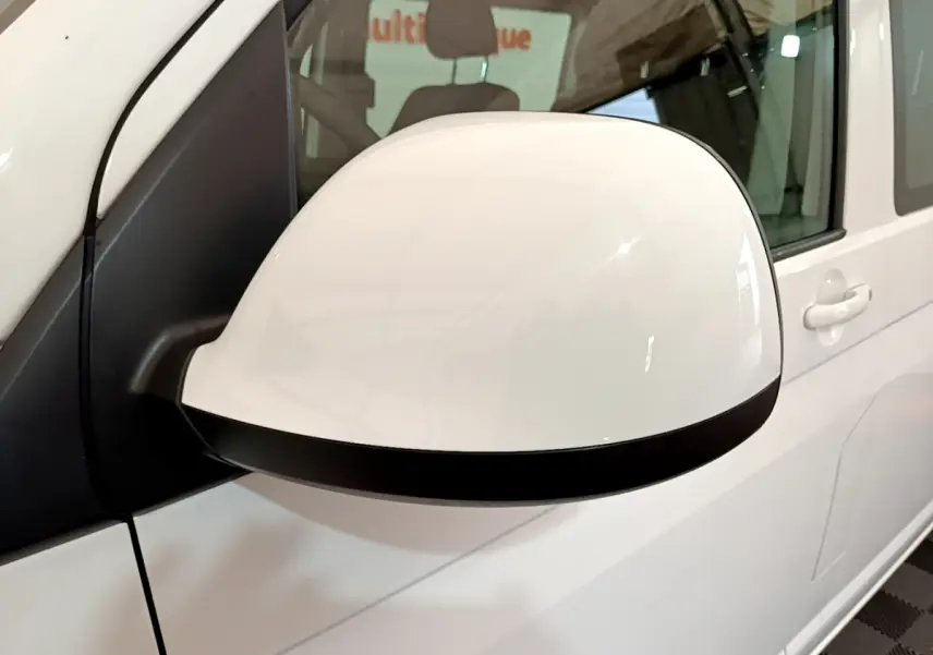 Gros plan sur le rétroviseur droit blanc du Volkswagen Transporter 2.0 TDi 150 DSG7 Business de 2021.