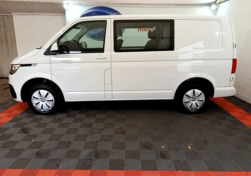 Vue de profil droit du Volkswagen Transporter blanc 2.0 TDi 150 DSG7 L1H1 Business avec vitres avant et arrière.