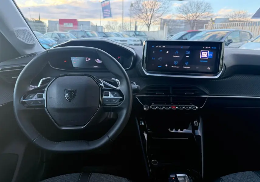 Vue intérieure frontale du tableau de bord et volant noir de la Peugeot 208 Hybrid 110 e-DCS6 Allure 2024 avec écran tactile.