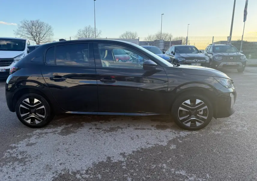Profil latéral droit d'une Peugeot 208 Hybrid 110 noire avec jantes alliage 16 pouces, stationnée en extérieur.