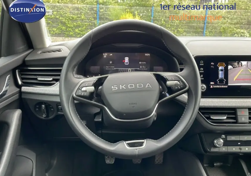 Vue frontale du volant SKODA SCALA 2025 avec tableau de bord numérique et écran central affichant la caméra de recul.