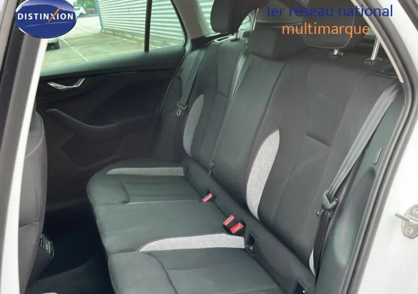 Vue intérieure côté droit des sièges arrière en tissu gris et noir d'une Skoda Scala blanc glacier 2025.