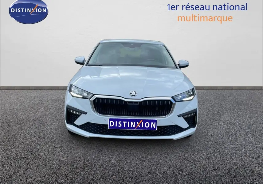 Vue frontale d'une Skoda Scala blanc glacier 2025 avec calandre noire et phares LED allumés.