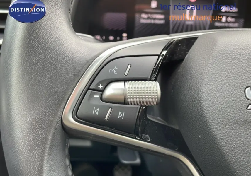 Gros plan sur les commandes multimédia au volant côté gauche d’une Skoda Scala blanche Glacier 2025.