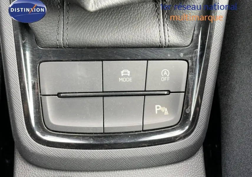 Gros plan sur les commandes de mode de conduite et d’aide au stationnement d’une Skoda Scala blanche Glacier.