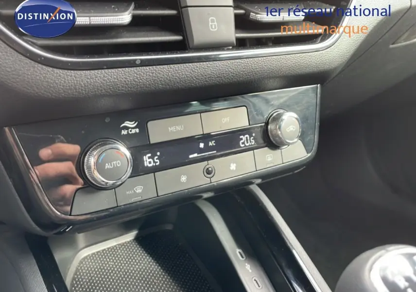 Vue rapprochée de la console centrale de la Skoda Scala blanche, mettant en valeur la climatisation automatique et la boîte manuelle.