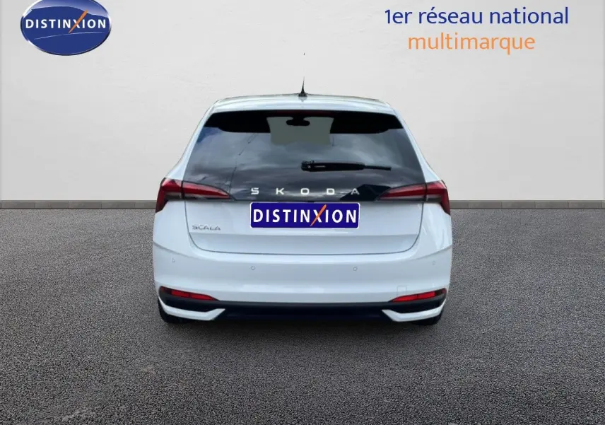 Vue arrière d'une Skoda Scala blanc glacier, avec feux arrière allongés et logo distinctif visible.