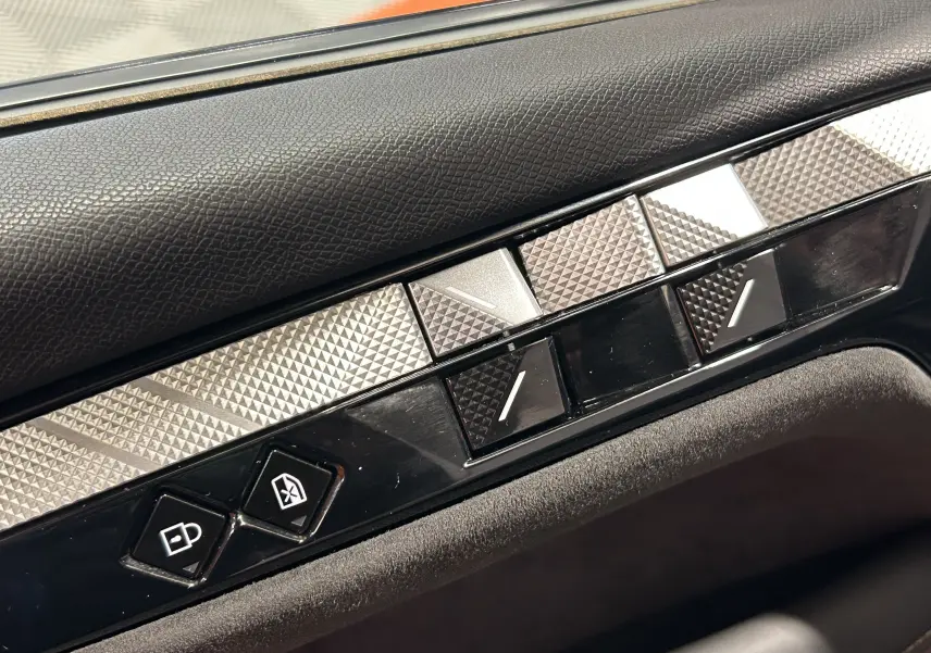 Détail des commandes de porte côté conducteur du DS4 2024 en finition Performance Line avec insert texturé argenté.