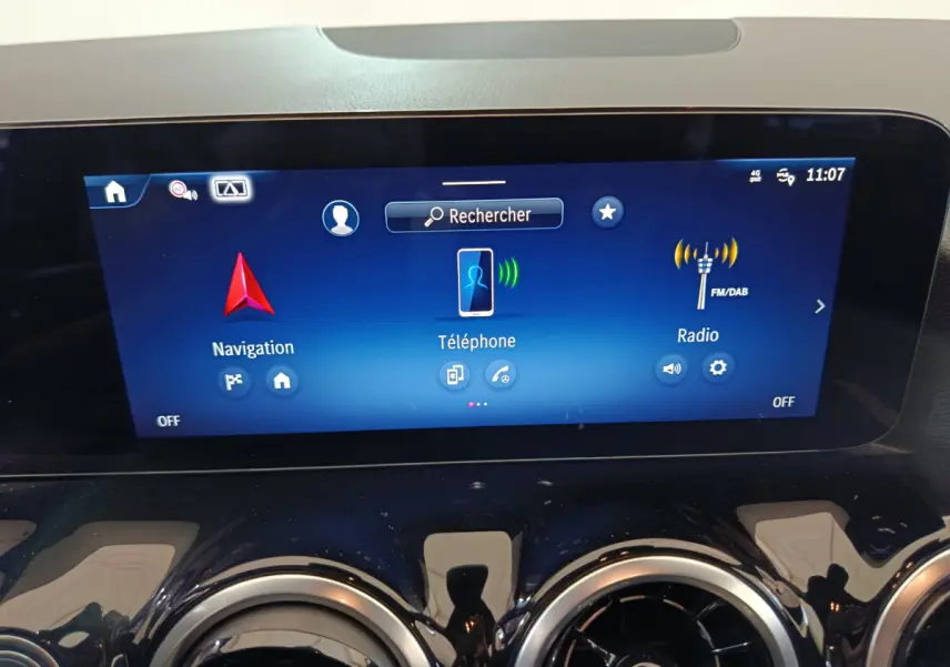 Écran tactile central bleu affichant navigation, téléphone et radio dans le tableau de bord du Mercedes GLA 250 e 2024.