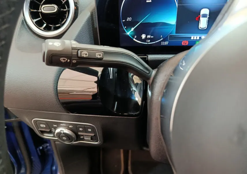 Gros plan sur le volant et le combiné d'instruments numérique du Mercedes GLA 250 e Business Line bleu, côté conducteur.