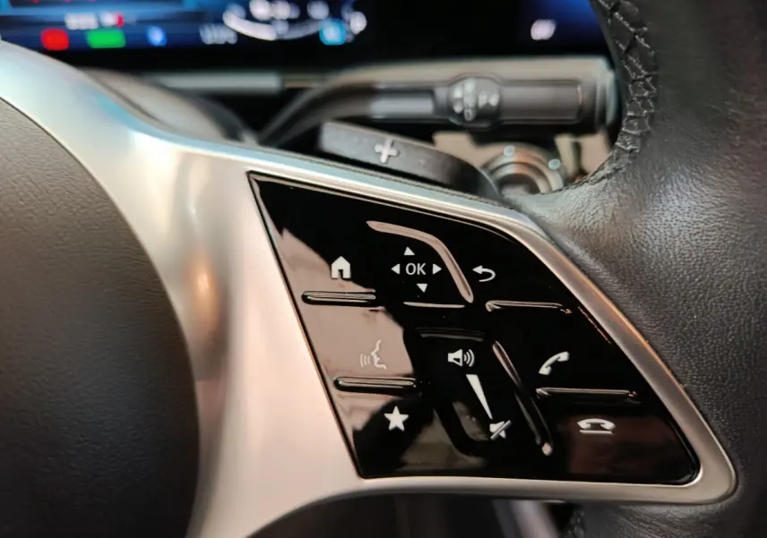 Gros plan sur les commandes tactiles du volant cuir du Mercedes GLA 250 e Business Line 2024 hybride rechargeable.